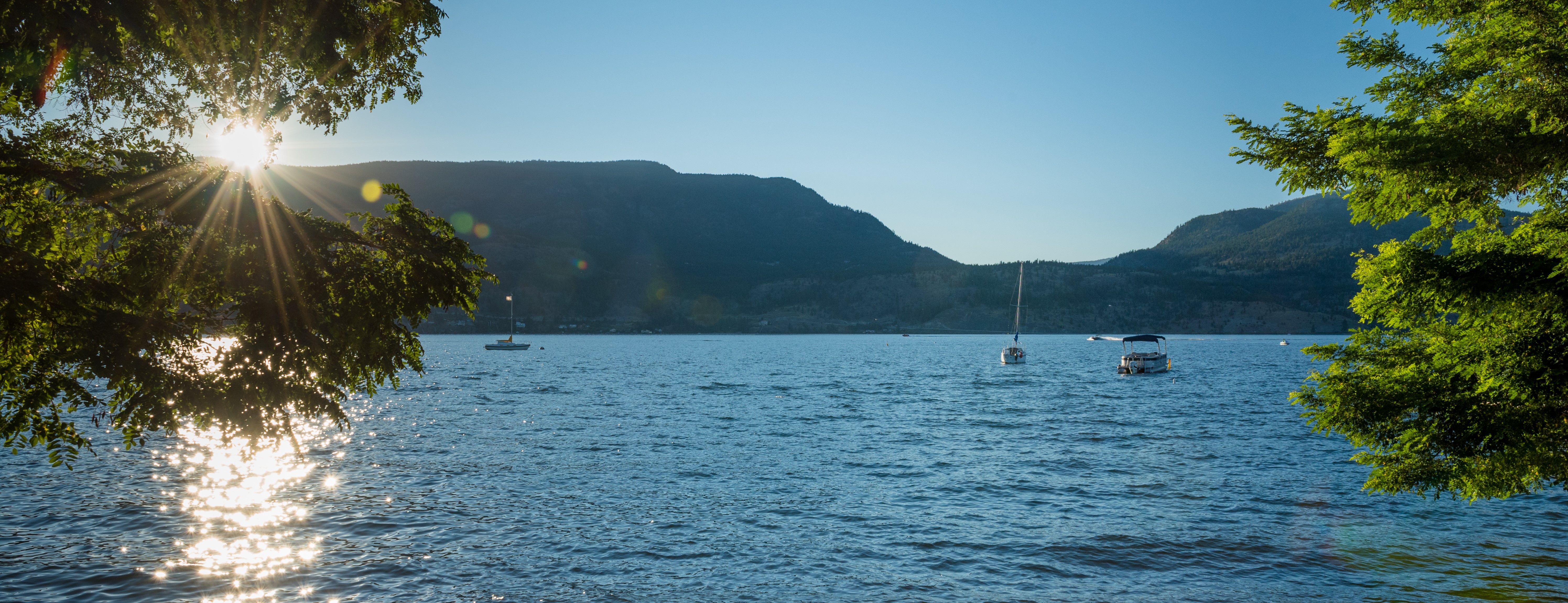 Boat in Okanagan Lake with view from Beach 