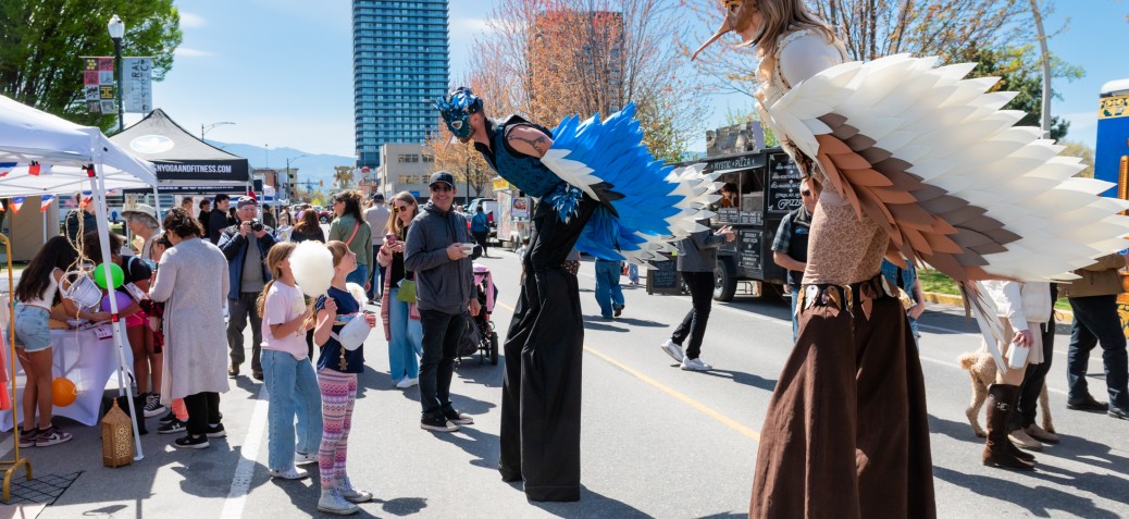 MapleFest fun performers on stilts representing birds interacting with children