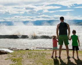 Father and two kids standing in front of Okanagan Lake